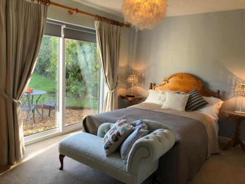 Carlton Corner Bed & Breakfast في Kibworth Harcourt: غرفة نوم بسرير وكرسي ونافذة