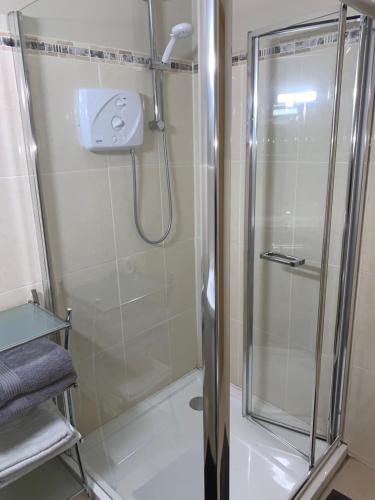 a shower with a glass door in a bathroom at Sliabh Amharc in Laragh