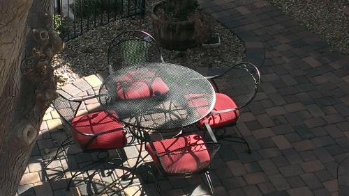 an outdoor table with red chairs and a table with at My Place Suites in Wickenburg