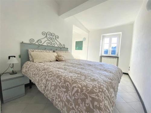 a bedroom with a large bed and a window at Le case della Lizza - Casa Rossa in Levanto