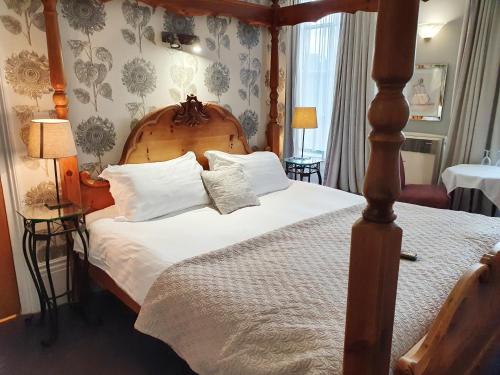 a bedroom with a large bed with a wooden headboard at Holmwood House Guest Accommodation in York