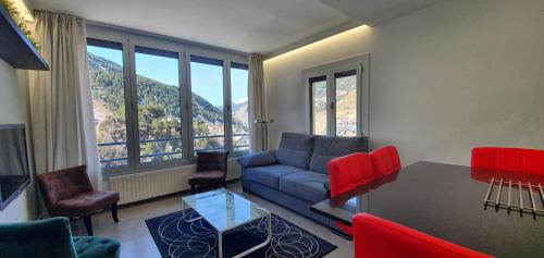 a living room with a couch and a table and chairs at Altissim Tarter - Inclès - Ransol in El Tarter
