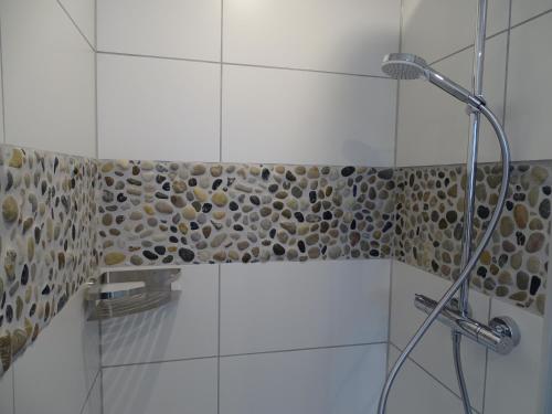 a bathroom with a shower with a stone wall at Rheinhessen Apartment in Nieder-Olm