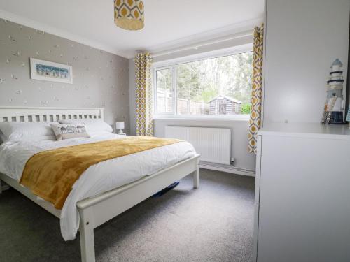 1 dormitorio con cama y ventana grande en Sea Salt en Bude