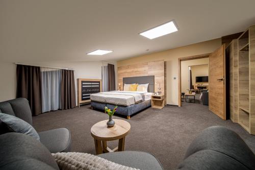 um quarto de hotel com uma cama e um sofá em Hotel Zelený potok em Pec pod Sněžkou