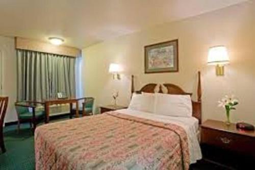 Best Inn في Wellsville: غرفة فندقية بسرير وطاولة وكراسي
