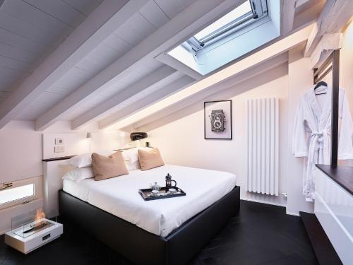 a bedroom with a large white bed with a skylight at OBERDAN SUITE Appartamento nel cuore di Bologna in Bologna