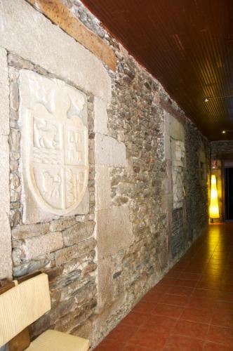 a stone wall with a crest on it at Albergue los Blasones in Sarria