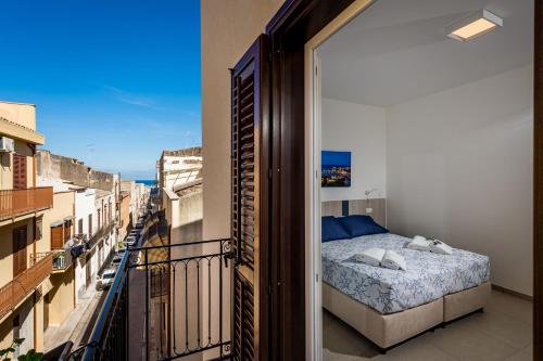 Schlafzimmer mit einem Bett auf einem Balkon in der Unterkunft Affittacamere Nanà in Castellammare del Golfo