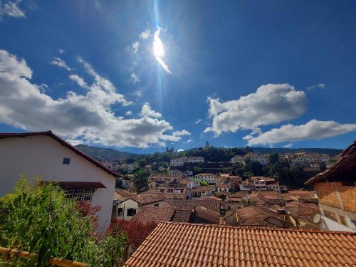 a view of a city with the sun in the sky at Pousada Janelas de Ouro Prêto in Ouro Preto