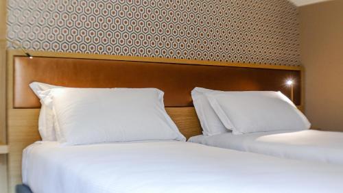 two beds sitting next to each other in a hotel room at Porto Vecchio Appartamenti in Lazise