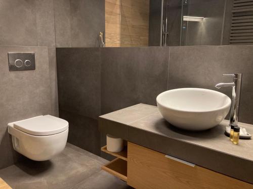 ein Badezimmer mit einem weißen Waschbecken und einem WC in der Unterkunft Baltiq Plaza Apartment in Gdynia
