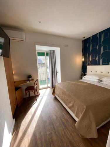 ナポリにあるHotel Europeo Napoliのベッドルーム1室(ベッド1台、デスク、窓付)
