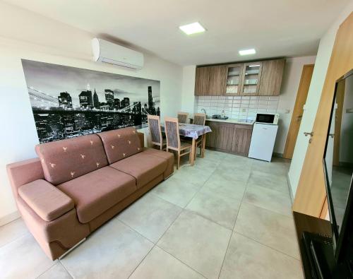 a living room with a couch and a kitchen at Anita Apartman Sopron in Sopron