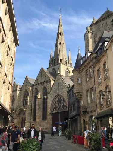 a large cathedral with a steeple in a city at Appartements du Vally - Guingamp in Guingamp