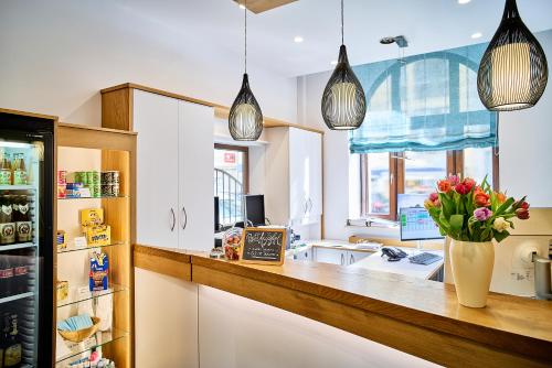 a kitchen with white cabinets and a counter with flowers in a vase at Brunnenhof City Center in Munich
