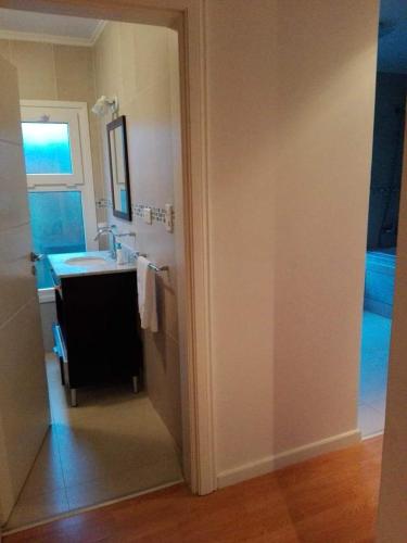 a bathroom with a sink and a vanity with a mirror at Villa Clarita Tandil in Tandil