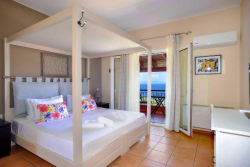 a bedroom with a bed with a view of the ocean at Bella Vista Villas & Suites in Gaios