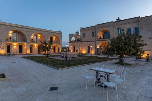 a courtyard with a table and chairs in front of a building at Relais Borgo Segine in Melendugno