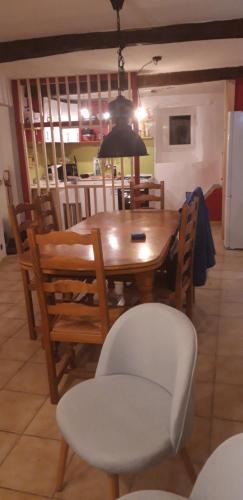a dining room table with a white chair and a table and chairsktop at Gîtes chez Daniel "Cevennes 2" in Mars