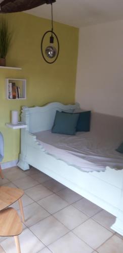 a bedroom with a white bed with a green wall at Gîtes chez Daniel "Cevennes 2" in Mars