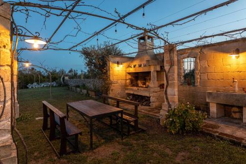 an outdoor patio with a table and a stone oven at Relais Borgo Segine in Melendugno