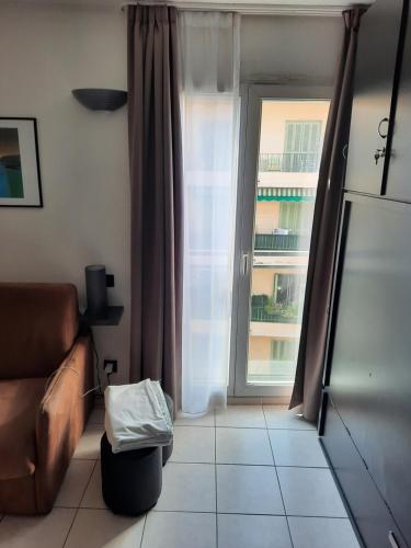 - un salon avec un canapé et une fenêtre dans l'établissement Californie Appartement, à Nice