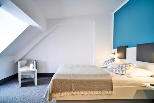 a bedroom with a large bed with a blue wall at Brunnenhof City Center in Munich