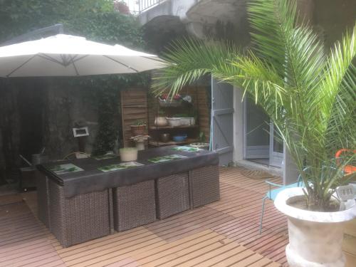 a patio with a table and a potted plant at LOFT CENTRE VILLE GANGES in Ganges