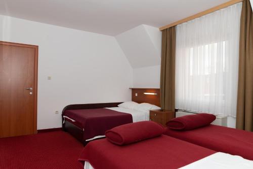 a hotel room with two beds and a window at Hotel Mirni Kutak in Otočac