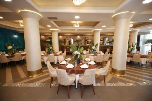 a dining room with tables and chairs and columns at Bajadera Lux in Belgrade