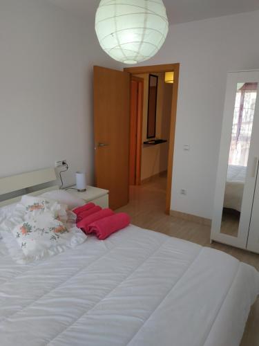 - un grand lit blanc avec 2 oreillers rouges dans l'établissement ApartmentHome, à Deltebre