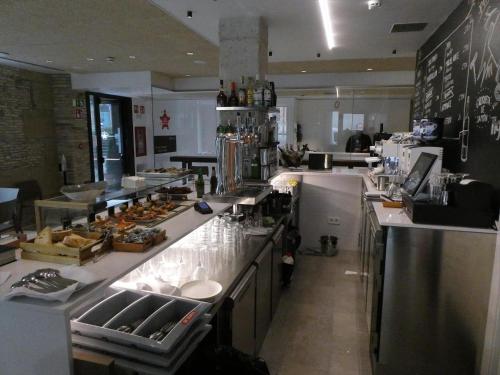 a kitchen with a counter with a lot of food at Hotel Ciudadela Pamplona in Pamplona