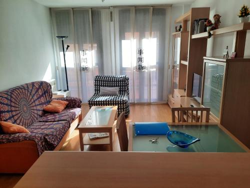 ein Wohnzimmer mit einem Sofa und einem Glastisch in der Unterkunft Gare de Madrid in Madrid