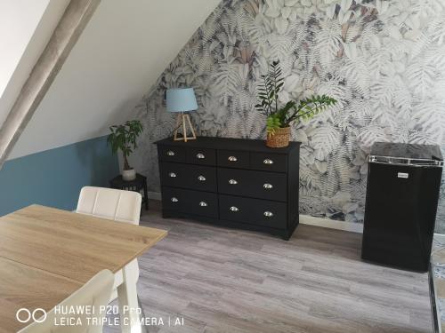 une salle à manger avec une commode et une table dans l'établissement L'atelier les hortensias, à Marquise