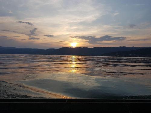 a sunset over a body of water with the sun setting at Smeštaj Zeka Tekija in Tekija