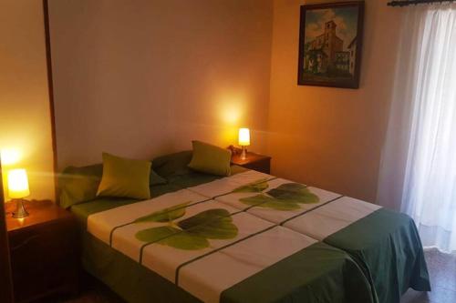 um quarto com uma cama, 2 candeeiros e uma janela em VITORETXEA casa rural AGUILAR DE CODES em Aguilar de Codés