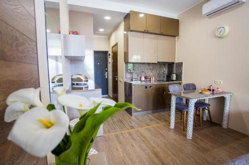 a living room with a table and a kitchen at Zgvadaca Kvariati apartment in Kvariati