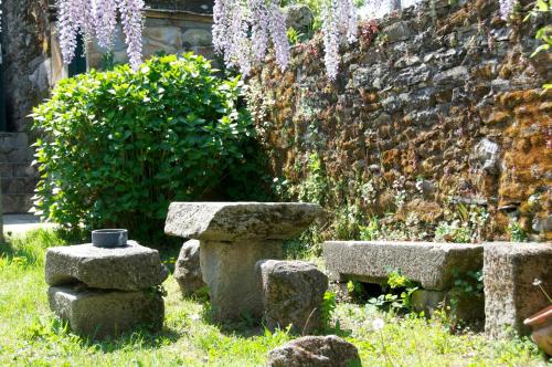 a garden with a stone bench and a wall at Albergue los Blasones in Sarria