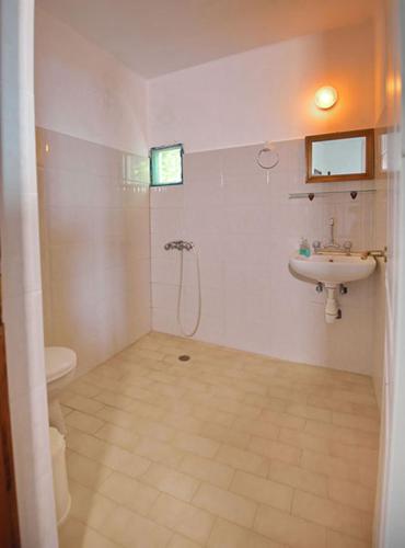 a bathroom with a sink and a toilet at Rizos Veranda - Rooms in Isómata