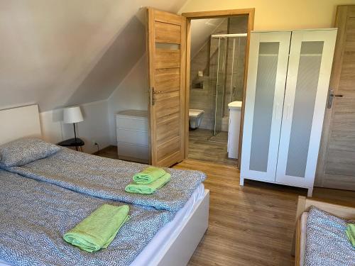 a bedroom with two beds with green towels on them at Sterburta in Rydzewo