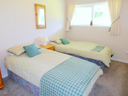 2 camas en una habitación con ventana en Beautiful 3-Bed Cottage in Cornwall, en Callington