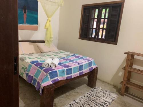 1 dormitorio con 1 cama con 2 toallas en Suítes Canto do Nema en Ilhabela