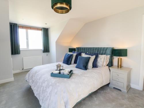 a bedroom with a large bed with blue pillows at Ger Y Mor in Cemaes Bay