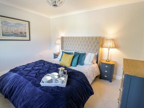 a bedroom with a bed with a blue comforter at Ger Y Mor in Cemaes Bay