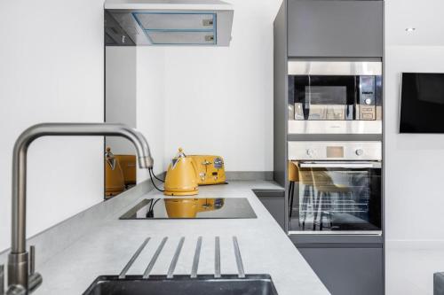 a kitchen with a sink and a yellow appliance at Winter Garden Apartments by Sasco in Blackpool