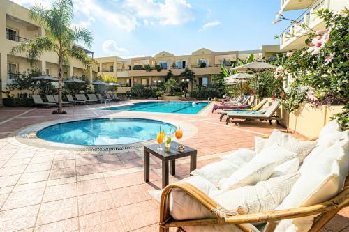 a patio with a pool and chairs and a table at Helios Apartments in Kato Daratso