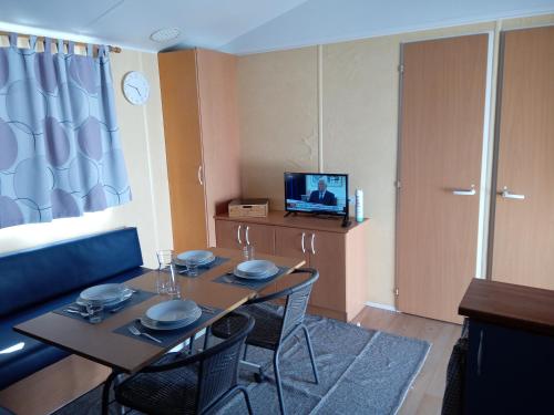 a room with a table and chairs and a television at Parque de Campismo de Fão in Fão