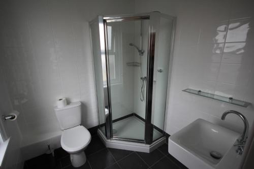 a bathroom with a shower and a toilet and a sink at Dolphins Hotel in Bournemouth