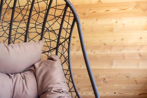 a person is holding a pillow in a hanging chair at Wanderhotel Teiserhof in Funes